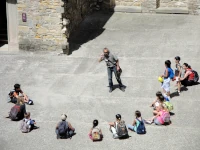 Un docente insegna a un gruppo di ragazzi seduti per terra in circolo