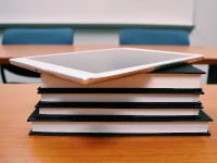 Piccola pila di libri, con in cima un tablet