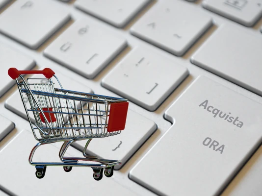 Tastiera dove il tasto Invio è sostituito dal tasto Acquista ORA, con un carrello della spesa che sormonta i tasti. Costruiamo negozi online per la tua attività di ecommerce