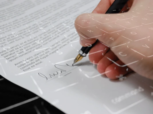 La firma su un documento cartaceo, che lascia intravvedere una tastiera di PC. Ti forniamo sia il modello per la carta intestata cartacea sia la carta intestata elettronica