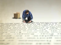 Uomo che compone testo su un enorme pavimento. Ricerca ed eventualmente sostituisce una stringa specifica all'interno di tutti i file testuali di una cartella specificata, con le sue sottocartelle