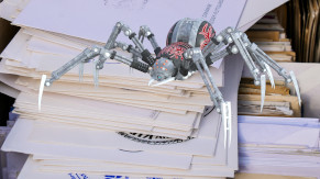 Un ragno robotico sopra un mazzetto di buste con lettere