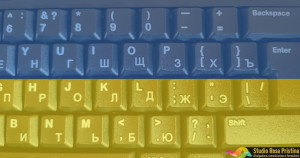Particolare di tastiera inglese/russa. In sovrapposizione semitrasparente vi è la bandiera ucraina